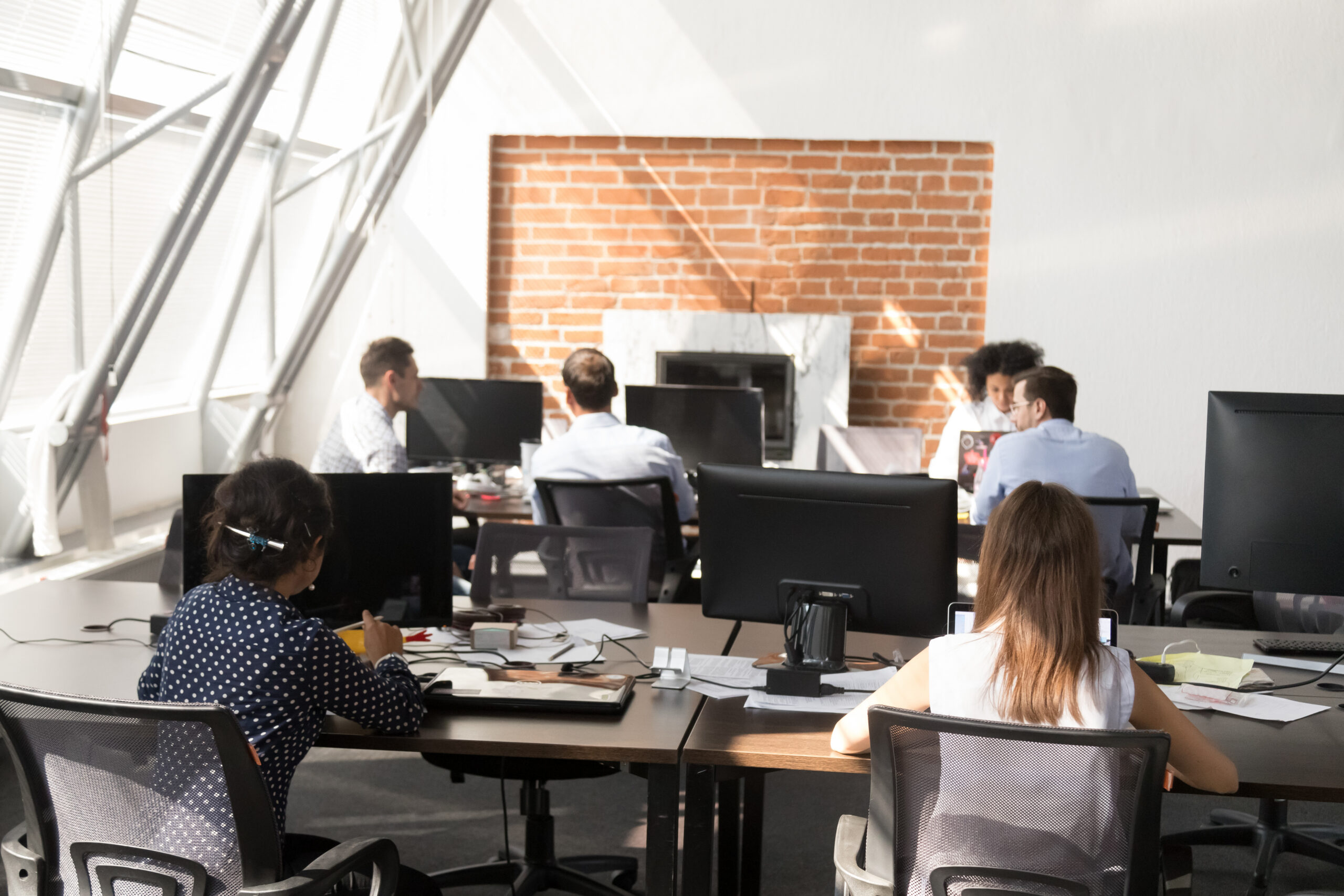 Workers using computers working at modern big open space